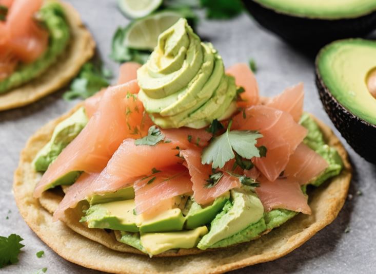 Plato de comida con sándwich de salmón ahumado y aguacate